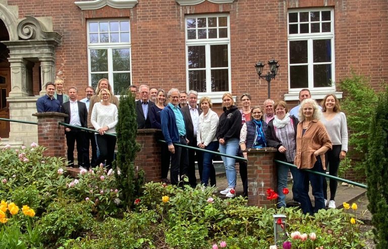Mitglieder der AktivRegion Gruppe von Menschen steht vor einem Gebäude mit Blumenbeeten im Vordergrund.