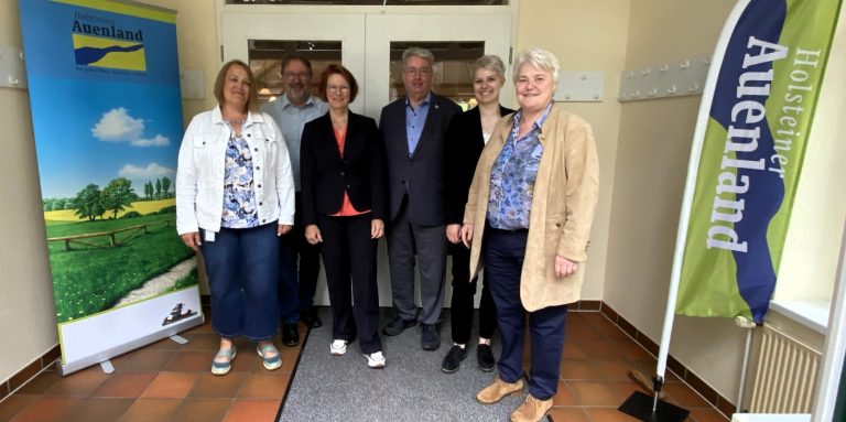 Vorstandsmitglieder der AktivRegion mit den Vertreterinnen des MLLEV im Dorfhaus Mönkloh Gruppenfoto von sechs Personen vor einem Eingang, mit zwei Bannern im Hintergrund.