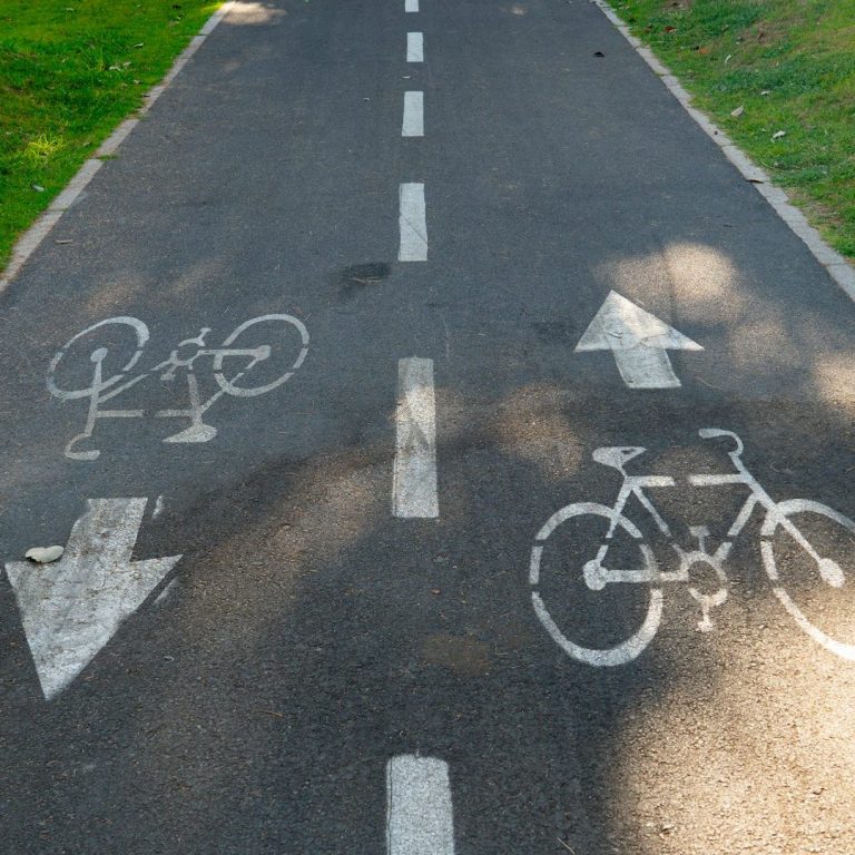 Fahrradweg mit Richtungspfeilen und Symbole für Radfahrer.