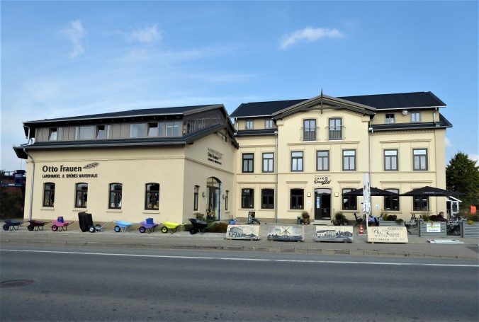 Frontansicht eines modernen Restaurants mit zwei Gebäuden und Freisitz.
