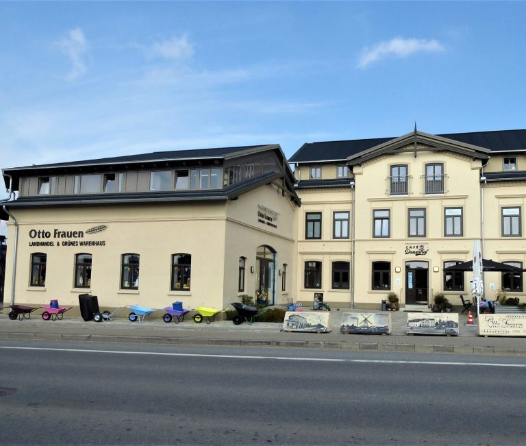 Zwei Gebäude mit terrakottafarbenen Fassaden, eines mit einem Restaurant-Schild.
