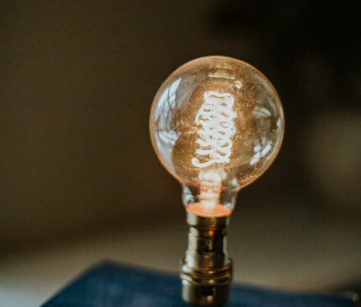 Eine Glühbirne mit warmem Licht auf einem Tisch.