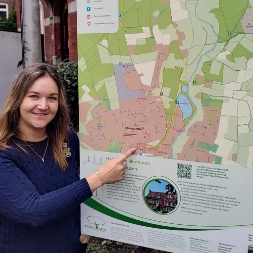 Eine Frau zeigt auf eine Karte mit geografischen Informationen und Umgebungsdetails.