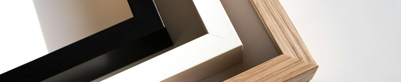 Drei stilvolle Bilderrahmen in Schwarz, Weiß und Holzoptik.
